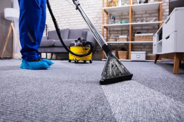 a worker cleaning carpet in house